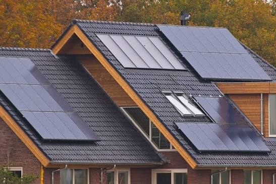 Technician inspecting photovoltaic panels on a residential roof